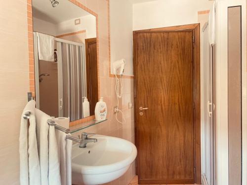 a bathroom with a sink and a wooden door at La Cascina Camere in Agerola
