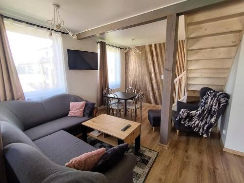 uma sala de estar com um sofá e uma mesa em OZZI LAND Resort em Sobącz