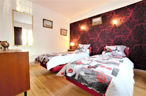 een slaapkamer met 2 bedden en een rode muur bij Gite du pommerat in Villenauxe-la-Grande