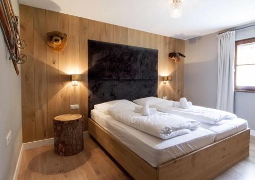 ein Schlafzimmer mit einem großen Bett und einer Holzwand in der Unterkunft Appart Laijola in Gaschurn