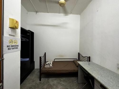 a small room with a bed and a table at Jiaxin Dormitory - Puteri Wangsa 家馨旅舍 in Ulu Tiram