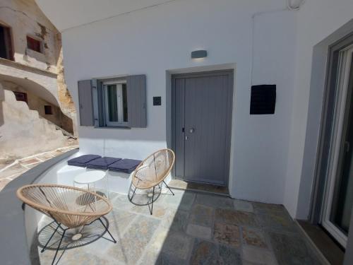 Zimmer mit einem Tisch, Stühlen und einer Tür in der Unterkunft Koutsounos in Kythnos