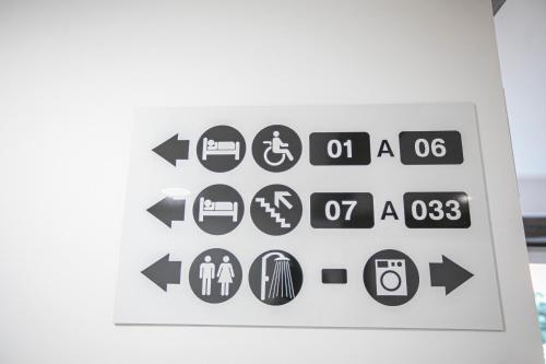 a sign with arrow signs on a wall at Albergue A Fabrica in Santiago de Compostela