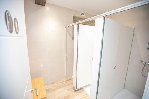 baño con ducha y puerta de cristal en Albergue A Fabrica, en Santiago de Compostela