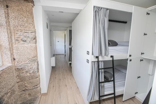 pasillo que conduce a un dormitorio con litera en Albergue A Fabrica en Santiago de Compostela