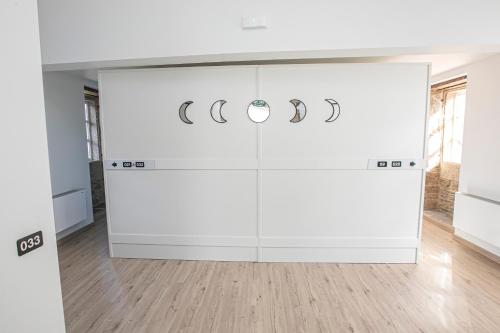 a room with a white wall with rings on it at Albergue A Fabrica in Santiago de Compostela