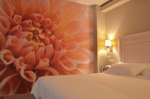 a bedroom with a painting of a flower on the wall at Hotel Jucamar in Cangas de Morrazo