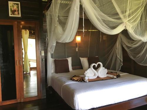 a bedroom with two beds with towels on it at Hillhouse - Koh Yao Noi in Ko Yao Noi