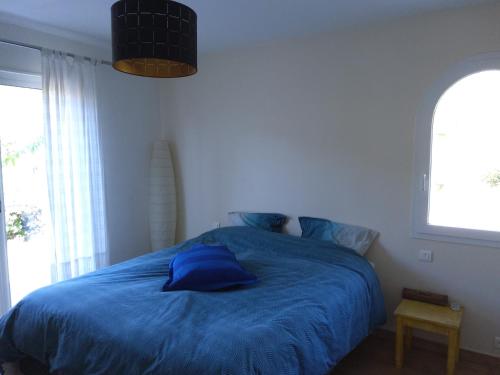 a bedroom with a blue bed with two windows at La provençale in Roquevaire