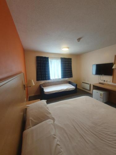 a hotel room with a bed and a window at Metro Inns Huddersfield in Huddersfield