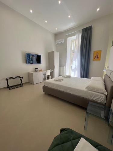 Un dormitorio con una cama grande y una ventana. en Dimora Chiaia 209, en Nápoles