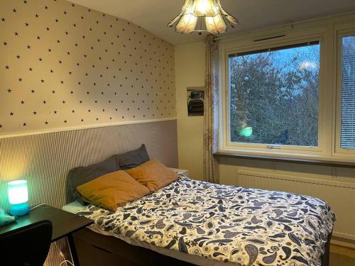 een slaapkamer met een bed en een raam bij Lovely Apartment in Göteborg