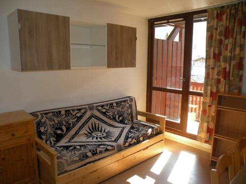 a couch in a room with a window at Au Coeur De La Station in Les Deux Alpes