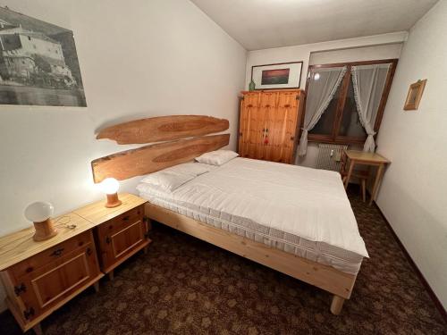 a bedroom with a bed and a dresser and a desk at Bilocale in centro ad 1 km dalla pista in Giustino