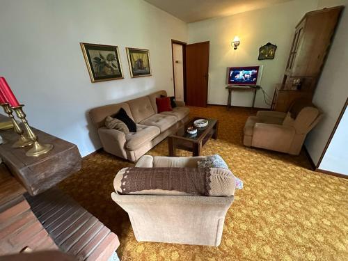 a living room with a couch and a tv at Bilocale in centro ad 1 km dalla pista in Giustino