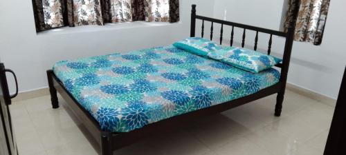 - un lit avec une couette bleue et blanche dans l'établissement Holiday homes in kidangoor kottayam kerala, à Kottayam