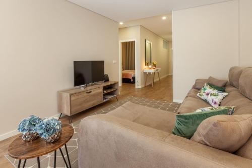 a living room with a couch and a flat screen tv at Liberdade Home Stay - Minho's Guest in Braga