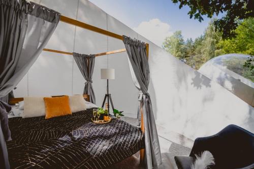 Habitación con cama y ventana en Golden Glamping nad Narwią, en Lubiel Stary