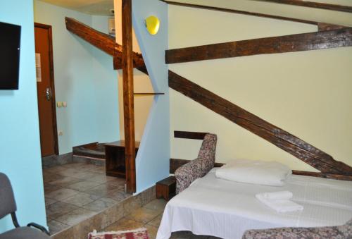 1 dormitorio con 1 cama y escalera en Pension Flamingo en Braşov