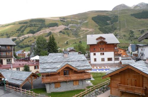 a group of buildings with mountains in the background at Au Coeur De La Station in Les Deux Alpes