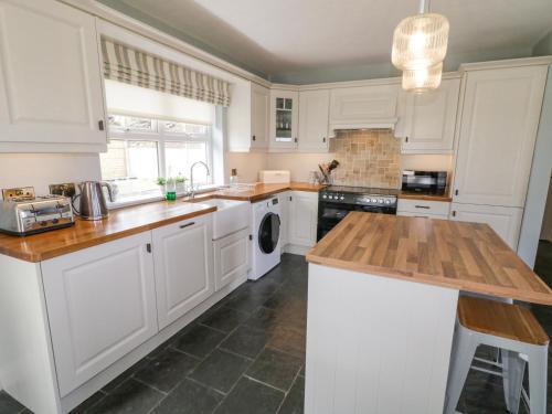 a kitchen with white cabinets and a wooden counter top at The Haven in Falcarragh
