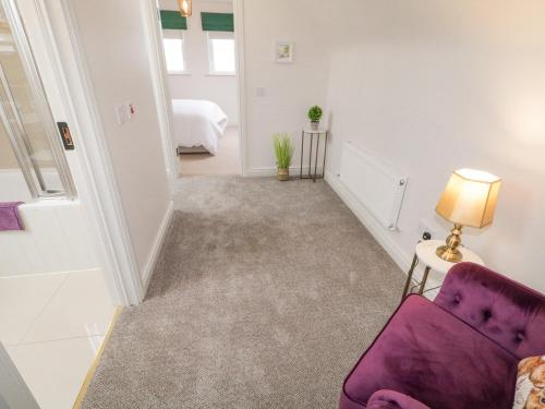 a living room with a purple chair and a bed at The Haven in Falcarragh