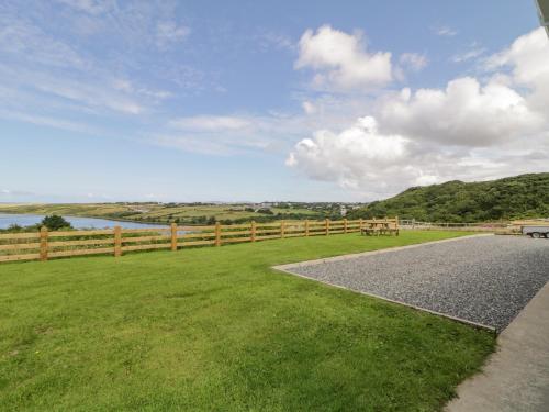 a gravel road next to a fence and a grass field at The Haven in Falcarragh
