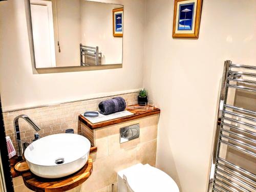 y baño con lavabo, espejo y aseo. en 18 Mill Wharf Apartment, en Berwick-Upon-Tweed