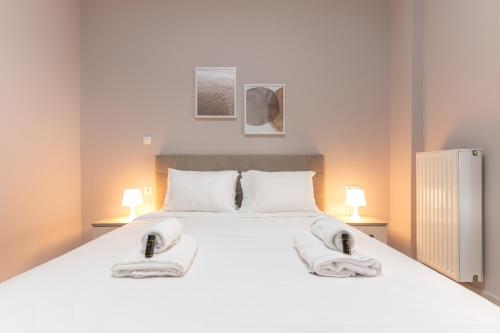 een slaapkamer met een groot wit bed en handdoeken bij Cosy 2BR Apartment next to Bars & Restaurants in Athene