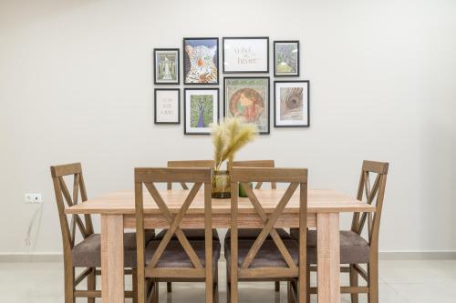 een eettafel en stoelen met foto's aan de muur bij Cosy 2BR Apartment next to Bars & Restaurants in Athene