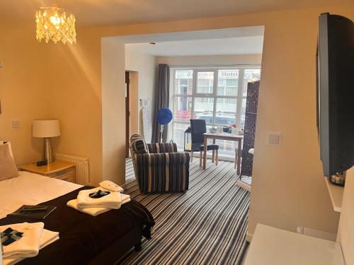 ブラックプールにあるThe Oxfordshireのベッドとリビングルームが備わるホテルルームです。