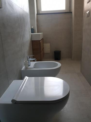 a bathroom with a toilet and a sink at L'artavello alloggio turistico in Marta
