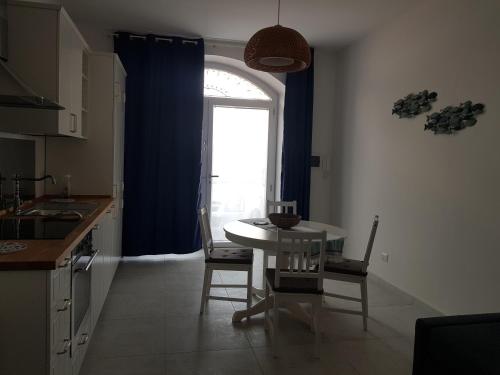 a kitchen with a table and chairs and a window at L'artavello alloggio turistico in Marta