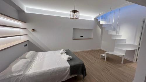 - une chambre avec un lit, une chaise et des escaliers dans l'établissement APARTAMENTO CAP SA SAL CON VISTAs PRIVILEGIADAS, à Gérone