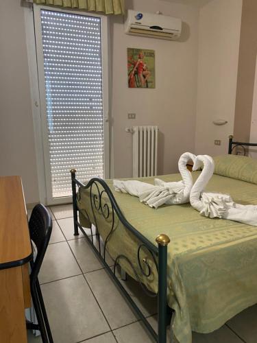 a bedroom with a bed with two swans on it at Hotel Esperia in Sammichele di Bari