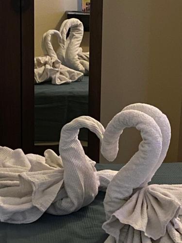 a pile of towels on a bed in front of a mirror at Hotel Esperia in Sammichele di Bari