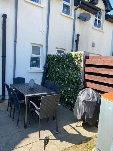 a black table and chairs next to a building at Ballyhack by the Sea in Arthurstown