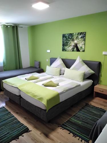Cama grande en habitación con paredes verdes en Mühlwinkler Hof, en Bergen