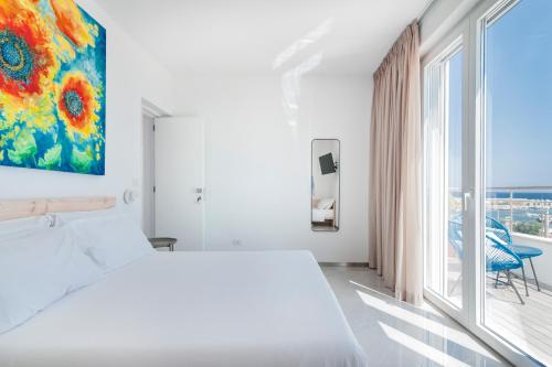 een slaapkamer met een wit bed en een groot raam bij THE VIEW B&B, terrace & more in San Foca