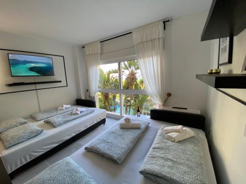 een slaapkamer met 2 bedden en een groot raam bij Modern Sea view Studio In Benal Beach in Benalmádena