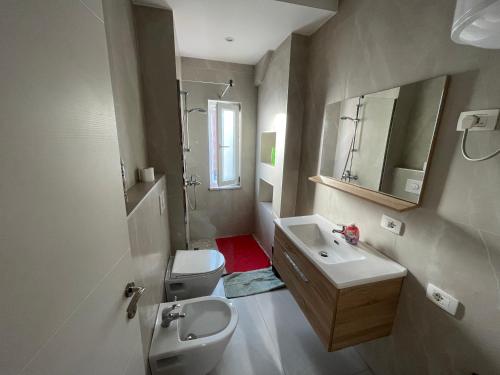 La salle de bains est pourvue d'un lavabo, de toilettes et d'un miroir. dans l'établissement DownTown View Modern Apartment, à Tirana