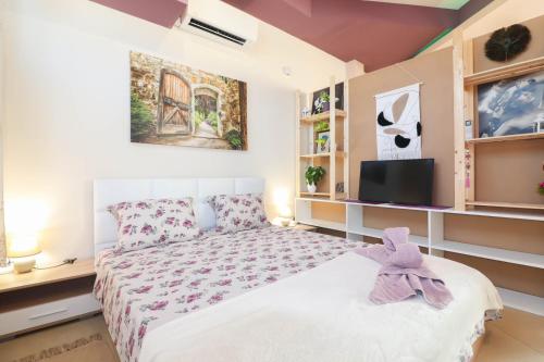 a bedroom with a bed and a tv at Студио Ариел in Varna City