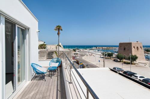 a balcony with two chairs and a view of a city at THE VIEW B&B, terrace & more in San Foca
