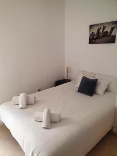 een groot wit bed met vier kussens erop bij Torneo Life Tranquilo en el centro in Sevilla