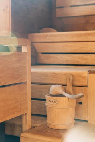 a wooden basket with a paddle in a sauna at Naturhotel Bauernhofer in Heilbrunn