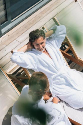 a man and a woman laying in bed at Naturhotel Bauernhofer in Heilbrunn