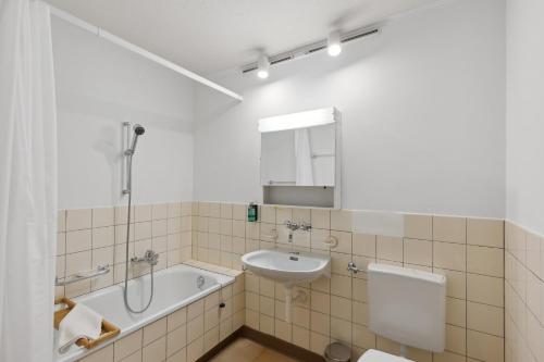 a bathroom with a sink and a bath tub and a toilet at PUNTSTRASSE 