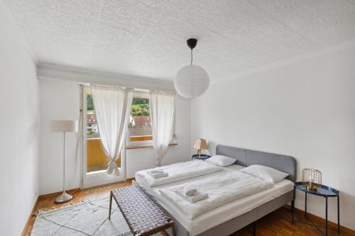 a white bedroom with a bed and a window at PUNTSTRASSE 