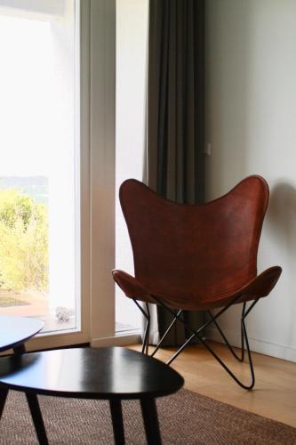a chair and a table in a room with a window at Langhoff & Juul Boutique Hotel og Restaurant in Ebeltoft