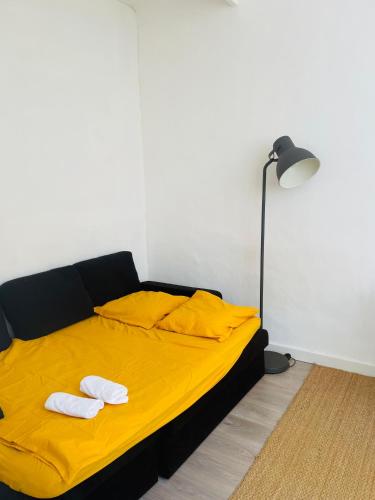 1 dormitorio con 1 cama amarilla y 2 toallas en Studio cosy en plein coeur de Marseille, en Marsella